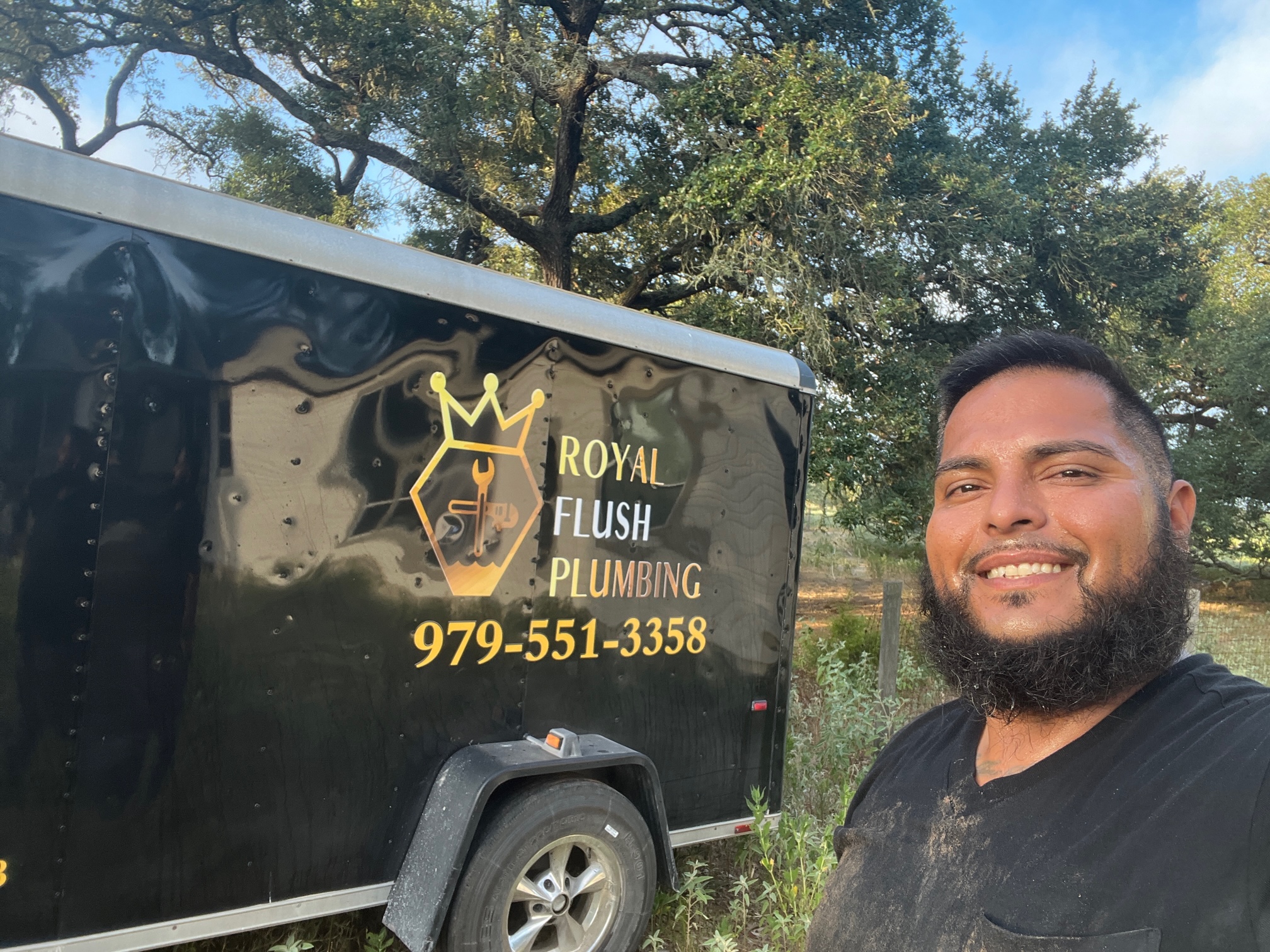 A man standing in front of a black trailer